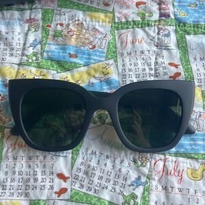 Tom’s sunglasses with green tint lenses